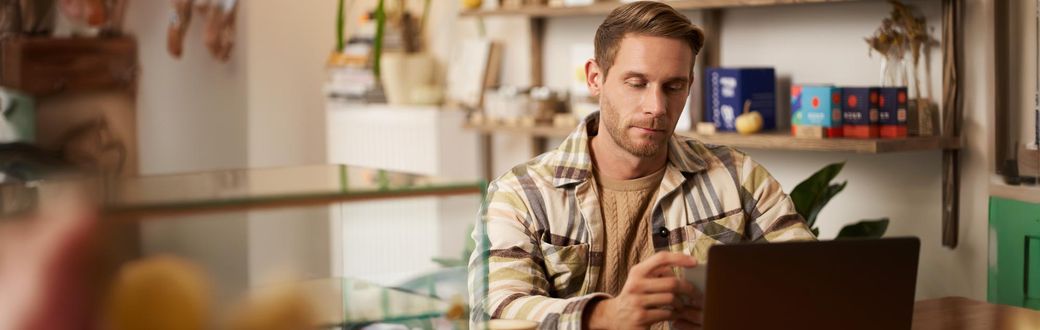 vállalkozó képzés online tanfolyamot végző férfi laptoppal egy kávézóban